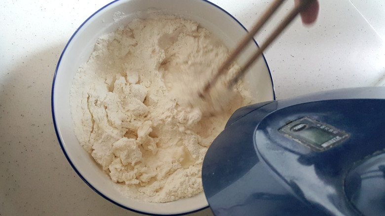 ~简易鸡蛋饼,用60-70度的温水慢慢地倒入面粉，搅拌。