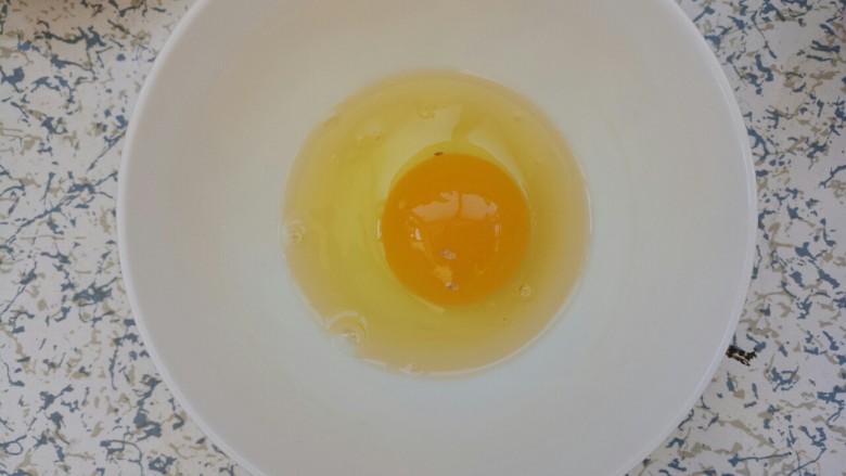 早餐黄油鸡蛋牛奶煎土司,把鸡蛋打入碗中