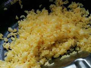 黄金炒饭,开始翻炒，就会呈现一粒粒黄金颗粒，不要加水，这样米饭没有炒起来好吃，加入胡椒粉调调口味，还有盐，米饭多就得多加免得太淡