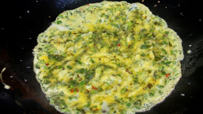 香椿煎鸡蛋,鸡蛋完全摊开后，重新加火力加热，过程中要不停的晃动锅子和在蛋边沿添点油，防止粘底。