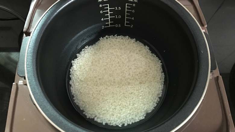 莲藕糯米汽水包,把泡好的糯米放入电饭煲里加半个指甲高度的水煮成米饭。