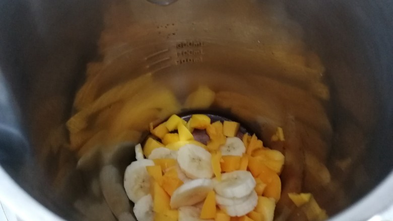 芒果香蕉奶昔,打开果汁料理机，加入切好的香蕉和芒果（如图）