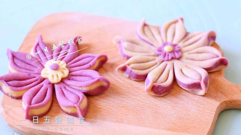 紫薯花朵馒头,在花朵上抹点水，将小花粘上，再弄一点紫薯面团搓圆放小花中间做花蕊，每个小花瓣用牙签压1-2道印痕。
