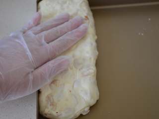 花生牛轧糖,带上一次性手套，将不烫手的棉花糖进行快速整形，成长方形。