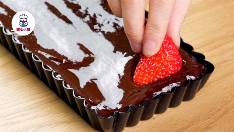 免烤草莓巧克力塔,将巧克力液倒入模具中，铺匀，摆入<a style='color:red;display:inline-block;' href='/shicai/ 592'>草莓</a>，撒上适量坚果碎，放入冰箱冷藏至少2小时