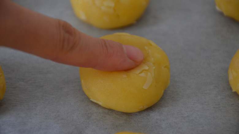 杏仁酥,烤盘上铺一层硅油纸，将搓好的面球放在烤盘上，用食指轻轻摁一下。
