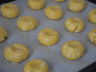杏仁酥,将小面球摁平成小圆饼即可。所有的面团都做好，依次有间距的放在烤盘上。

