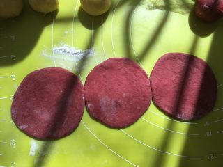 双色玫瑰花面包,撒一点干粉，将松弛好的红色面团擀成圆片，大小要均匀