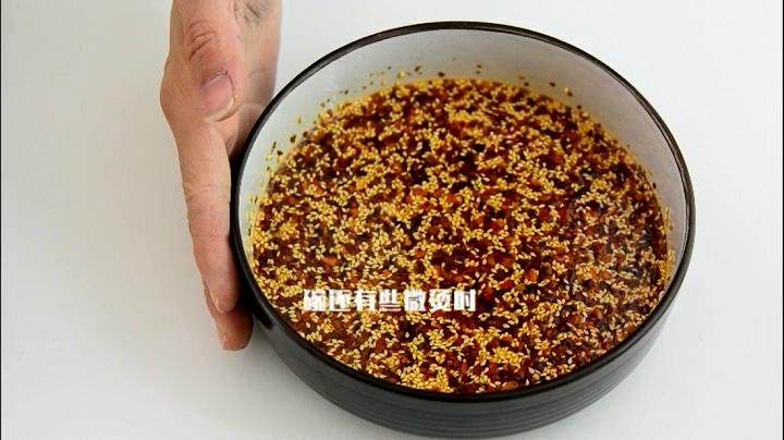 自己动手做辣椒油，好吃又卫生,碗还有些微烫的时候倒入一勺辣椒粉，搅拌均匀。