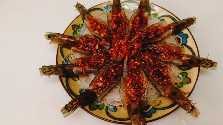 蒜蓉粉丝开屏虾,将炒好的蒜蓉汁浇在虾的开背处，多余的浇在粉丝上