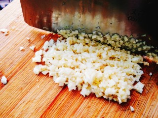 蒜蓉粉丝开屏虾,大蒜用刀切成碎末或专用工具压成蒜蓉。