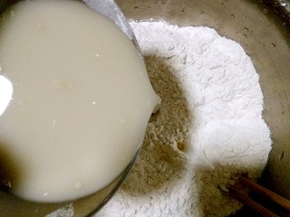 肉夹馍,冲开的酵母粉水一点一点倒进面里，用筷子搅拌成雪花状。