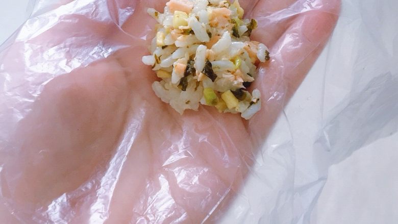 海苔牛油果三文鱼饭团,拿一张保鲜膜或者保鲜袋，取一勺放在保鲜膜上
