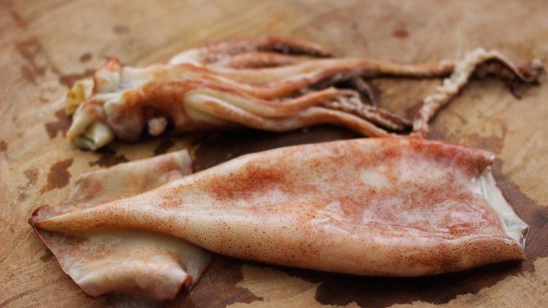 空气炸锅鱿鱼圈🦑【宝宝辅食】,洗净后的鱿鱼放在菜板上、鱿鱼头不用、可以和其它食材烹制