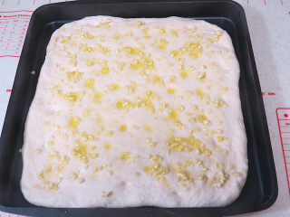 意大利面包【香草佛卡夏】,在按好小坑的面团上均匀涂抹上准备好的蒜蓉橄榄油