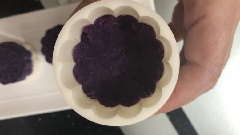 紫薯山药糕,月饼模具刷少点油，先放一半紫薯进去压紧。