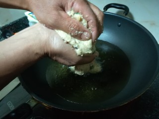 #客家美食#薯丸,用手挤到锅里，当然用勺子舀也是可以的，就是用勺子舀，形状很不规则，用手挤形状会比较好看。