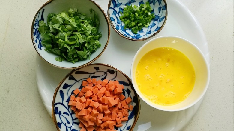 香菜蛋炒饭,鸡蛋打散，火腿肠切丁，香菜切小段，葱切成葱花备用。