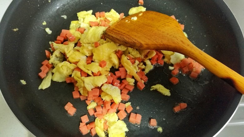 香菜蛋炒饭,把火腿肠炒至表面变色。