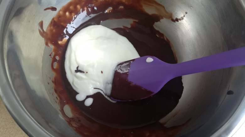 四季慕斯四重奏,称取20克打发好的淡奶油加入巧克力酱中，然后快速搅拌均匀