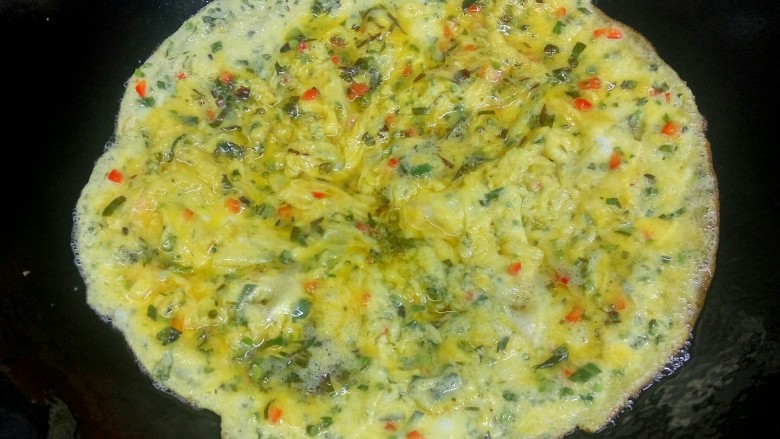 香椿煎鸡蛋,当蛋液全部凝固，呈金黄色时就可以翻锅煎另一面了。
