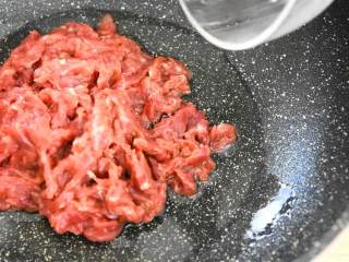 芹菜牛肉,锅里倒入两大勺油，滑散牛肉丝，炒至变色。