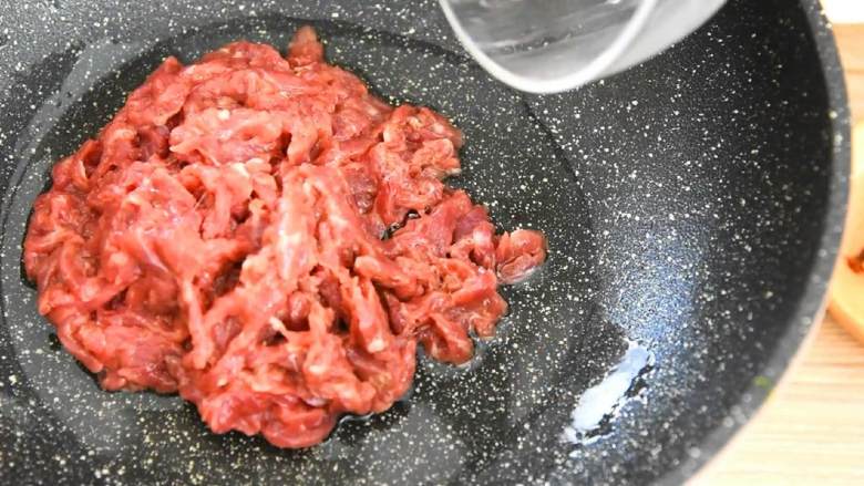 芹菜牛肉,锅里倒入两大勺油，滑散牛肉丝，炒至变色。