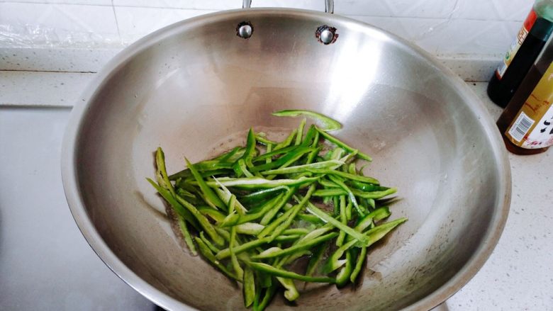 下饭菜~青椒肉丝,油六七分热的时候下青椒翻炒。