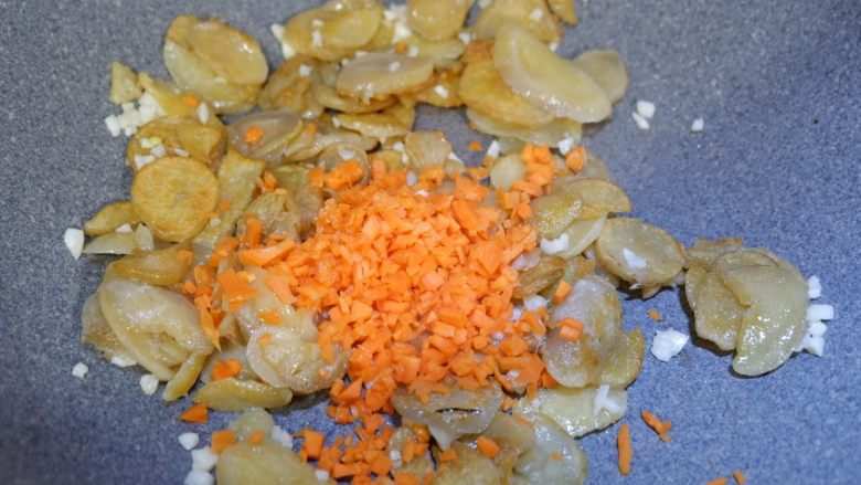 孜然土豆干,在加入胡萝卜碎，翻炒均匀