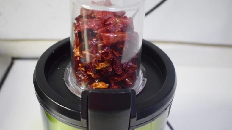 香而不辣的花生油辣椒,炒好的辣椒段放入料理机的绞肉杯中，启动1档，打碎约10秒即可，分批次的打碎辣椒段。
