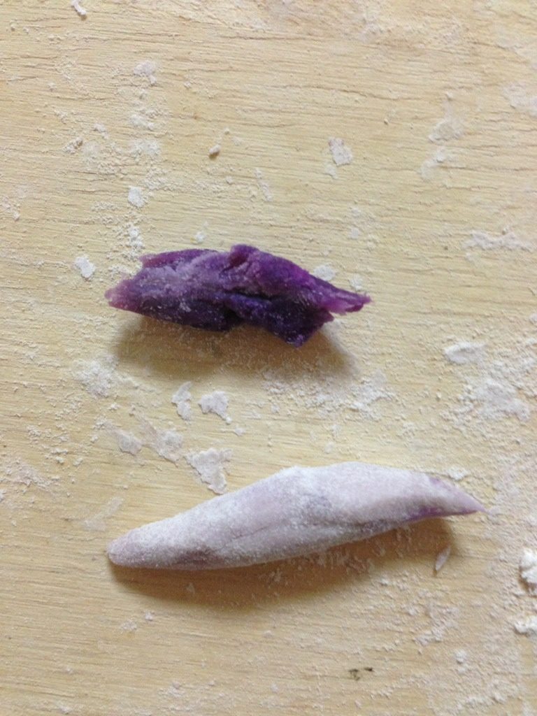 紫薯花卷,把一个小挤子一分为二，揪出一半包住紫薯泥后搓成梭形，或直接把紫薯泥搓成梭形，用来做花心；