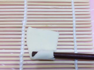 自制空心面（饺子皮版）,取一片放在寿司帘上，用筷子压住角向上卷，