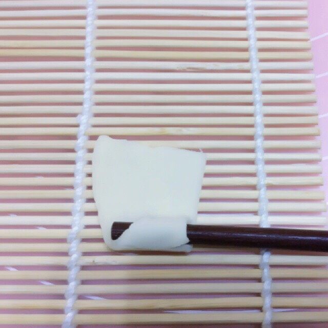 自制空心面（饺子皮版）,取一片放在寿司帘上，用筷子压住角向上卷，