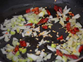 三色炒豌豆,锅内放1勺花生油，加葱花、干红辣椒碎爆香。