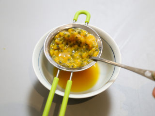 低脂百香果沙拉,用勺子将晒网中的百香果汁过滤到碗中。