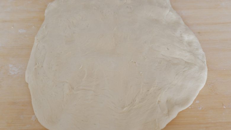 圆白菜虾皮素包子,案板上撒少许干粉，将面团取出按压排气。
