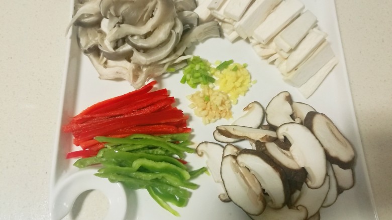 蚝油菌菇,杏鲍菇，草菇洗净后切片，蘑菇用手撕成片状，青红椒切丝，葱姜蒜切未备用。
