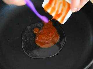 如果你爱吃甜，那么绝对不能错过这道菜,锅里倒入一勺油，放番茄酱滑散。