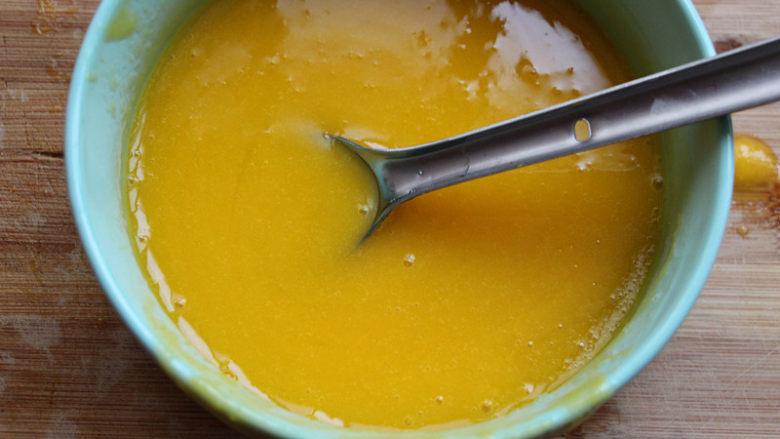 8寸芒果慕斯,冷藏大概两个小时的时候来做镜面，将50克的芒果果肉加150克的纯净水搅打成芒果汁，另外5克吉利丁片用同样的方法融化成液态，加入芒果汁搅拌均匀。