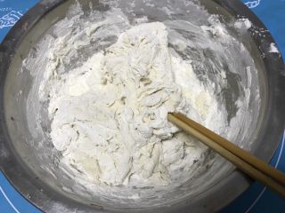 韭菜鸡蛋盒子,把化开的酵母水倒入面粉中用筷子搅拌均匀。