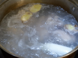 香辣莲藕焖猪手,锅中加入水，姜片，1勺料酒煮沸，放入猪手焯水。