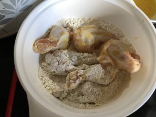 外酥里嫩的健康秘制炸鸡,沥一下蛋液，然后放入裹粉里打个滚。一次准备五六个鸡翅根。