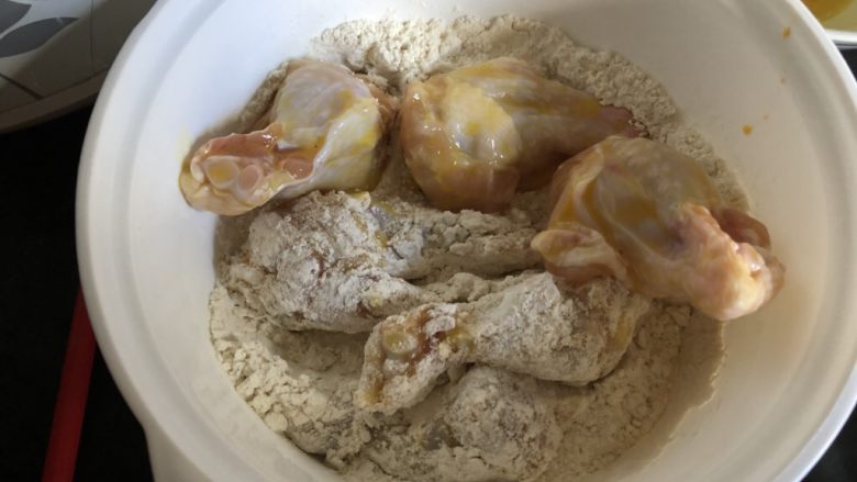 外酥里嫩的健康秘制炸鸡,沥一下蛋液，然后放入裹粉里打个滚。一次准备五六个鸡翅根。