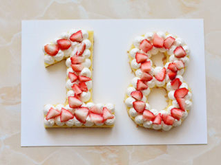 网红数字蛋糕,草莓切成自己喜欢的形状，放在蛋糕上面，再放上一层数字蛋糕，挤满奶油，放上草莓、棉花糖、和橙子。在蛋糕的最上层，筛上一层薄薄的糖粉，就可以食用了
