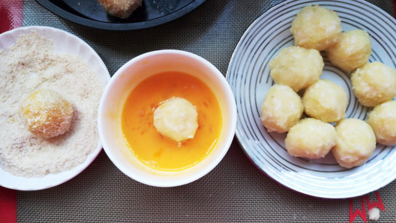 芝士虾球,包好的土豆虾球，沾一层蛋液，裹一层面包糠，放在刷了油的烤盘。