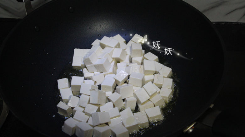 孜然小葱煎豆腐,油锅烧热，下豆腐块煎。丢下去就可以了，不用来回翻动，豆腐嫩，容易碎。