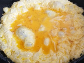 青蒜炒鸡蛋,转动锅让鸡蛋摊平并慢慢熟