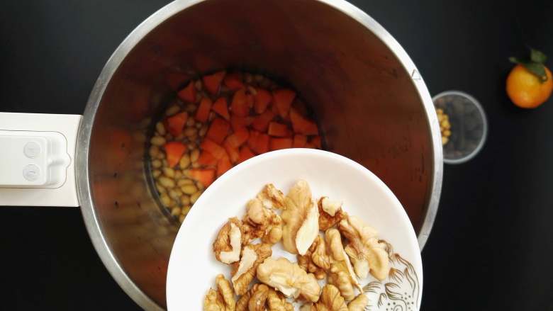 营养满满的胡萝卜核桃豆浆,将三种食材加入豆浆机中，加入清水至豆浆机内桶中水位线1000毫升至1200毫升处，一般这个量就是三个人的量。