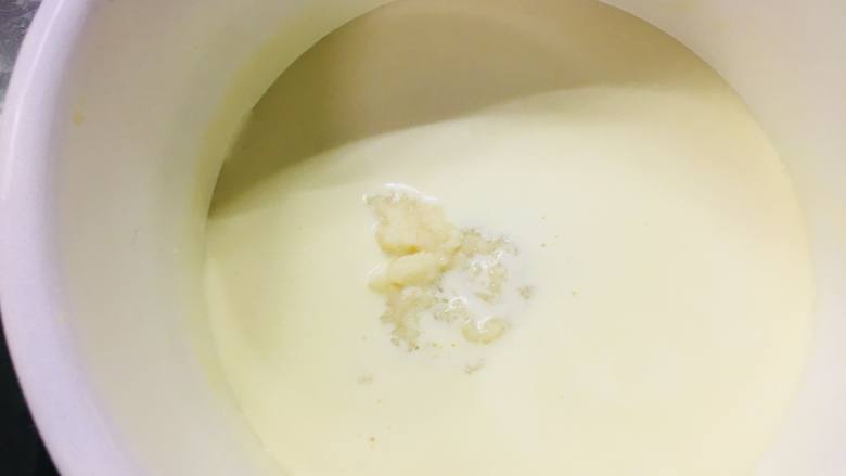 冻芝士魔方,将剩下的牛奶与淡奶油混合加热，将融化的吉利丁粉加入进去。（如果你用吉利丁片，这里将泡软的吉利丁片放入牛奶与淡奶油中）搅拌至完全溶解。