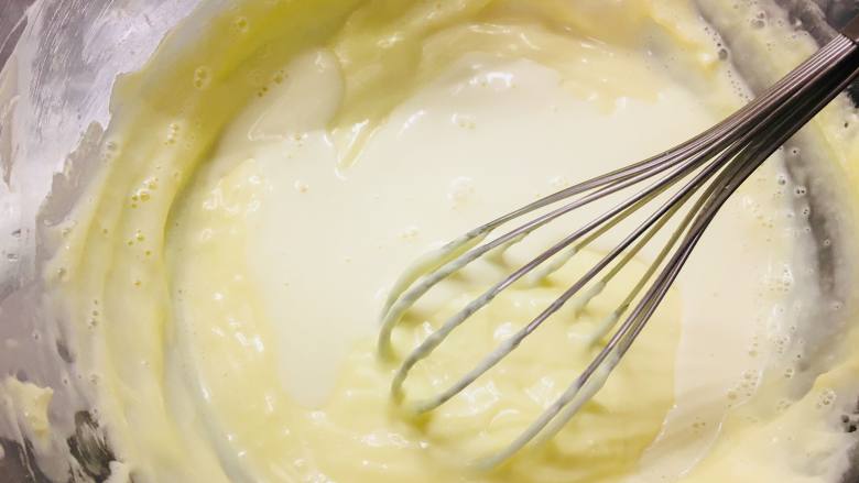 冻芝士魔方,分次！将淡奶油混合物倒入奶酪糊中。充分搅拌均匀。